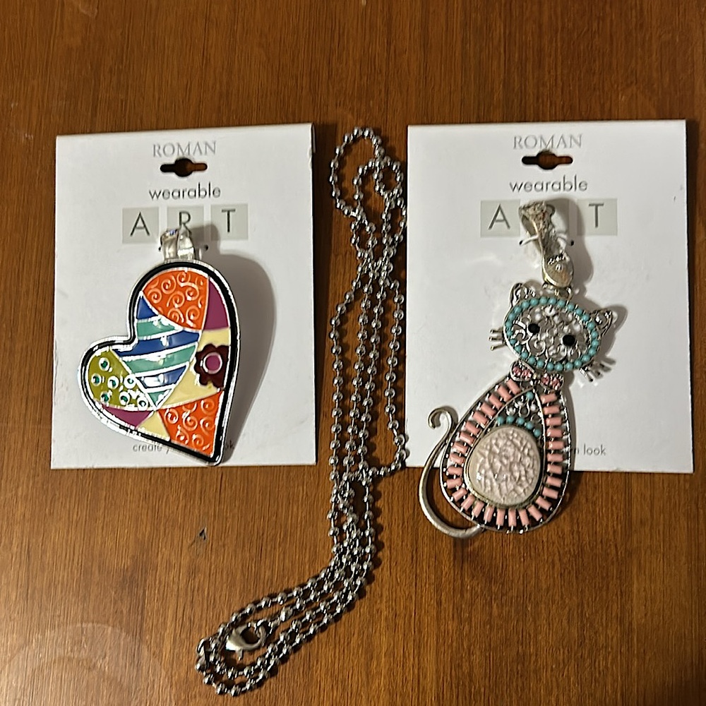 NWT Roman Wearable Art. Two Silver Tone Enhancer Pendants and a Silver Chain.